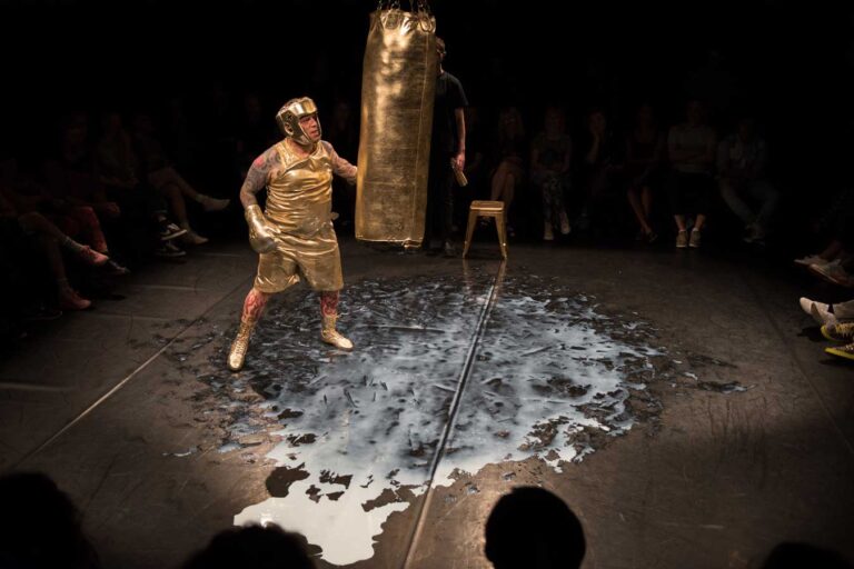 artista realizando performance corporal en escenario