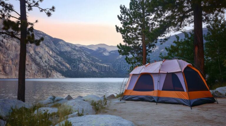 lago rodeado de montanas y camping